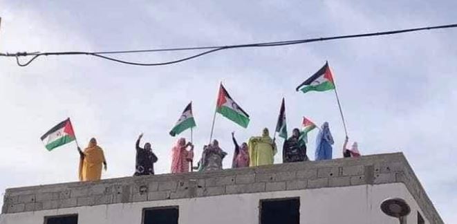 Foto de la familia Jaya en el tejado portando banderas saharauis